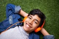 Jamming to his favorite tunes. A young boy relaxing on the lawn and listening to music. Royalty Free Stock Photo