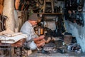 An Indian cobbler at work in his shop