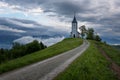 Jamnik church on a hillside in the spring, foggy weather at sunset in Slovenia, Europe. Mountain landscape shortly after spring ra Royalty Free Stock Photo