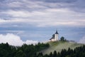 Jamnik church on a hillside in the spring, foggy weather at sunset in Slovenia, Europe. Mountain landscape shortly after spring ra Royalty Free Stock Photo