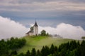 Jamnik church on a hillside in the spring, foggy weather at sunset in Slovenia, Europe. Mountain landscape shortly after spring ra Royalty Free Stock Photo