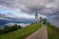 Jamnik church on a hillside in the spring, foggy weather at sunset in Slovenia, Europe. Mountain landscape shortly after spring ra Royalty Free Stock Photo