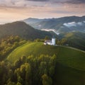 Jamnik, Slovenia - Aerial view the church of St. Primoz in Slovenia near Jamnik and Bled with beautiful clouds and Julian Alps. Royalty Free Stock Photo