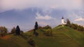 Aerial drone view of Jamnik, Slovenia. Rainbow, Alps and Church of St. Primoz