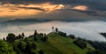 Jamnik, Slovenia - Magical foggy summer morning at Jamnik St.Primoz hilltop church. at sunrise