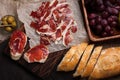 Jamon Iberico with white bread, olives on toothpicks and fruit on a wooden background. Top view Royalty Free Stock Photo