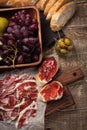 Jamon Iberico with white bread, olives on toothpicks and fruit on a wooden background. Top view Royalty Free Stock Photo