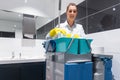 Janitor or charlady with her work tools looking at camera in toilet