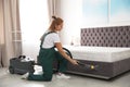 Janitor cleaning bed with professional equipment