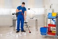 Janitor Cleaning Floor With Broom In Office Royalty Free Stock Photo