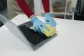 Janitor cleaning the office, Clean the notebook with a rag, wear gloves and wipe with a towel, Wear rubber gloves when working