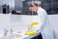 Janitor cleaning sink in public washroom