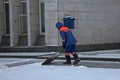 Janitor cleaning snow on the sidewalk with a shovel Royalty Free Stock Photo