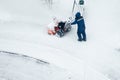 Janitor cleans the street from snow