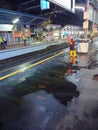 janitor is draining puddle of water at jakarta train station