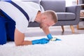 Janitor Looking At Carpet With Magnifying Glass Royalty Free Stock Photo