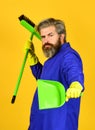 Janitor professional. Bearded hipster blue uniform with broom. Gardener cleaning service man. Garbage removal. Cleaning