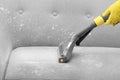 Janitor removing dirt from sofa with upholstery cleane