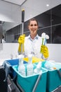 Janitor or charlady with her work tools looking at camera in toilet Royalty Free Stock Photo