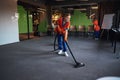 Janitorial staff using a microfiber scrubber and a vacuum cleaner Royalty Free Stock Photo