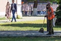 Janitors with a broom and trash bag, clean the footpath