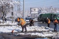 Janitors are cleaning snow on street after snowstorm. Manual work. Ice storm.