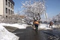 Janitors are cleaning snow on street after snowstorm. Manual work.