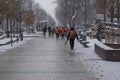 Janitors team are going to clean snow. Workers are going to remove snow in snowfall. Workers with snow shovels in snowfall.