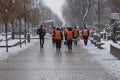 Janitors team are going to clean snow. Workers are going to remove snow in snowfall. Workers with snow shovels in snowfall.