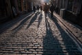 January 2020, Abstract shadows of people walking in a street of the city. The sidewalk is sprinkled with granite crumb Royalty Free Stock Photo