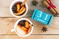 January 31. Blue cube calendar with month and date and cups with mulled wine