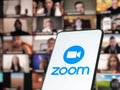 11 January 202 - Bucharest, Romania: Smartphone starting Zoom Cloud Meetings app with meeting on a background monitor