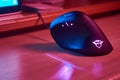 Ergonomic gamer vertical mouse on desktop in room with blue and red lights. Side view Royalty Free Stock Photo