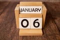 January 6 displayed wooden letter blocks on white background with space for print. Concept for calendar, reminder, date.