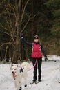 January 24, 2023 Moscow Russia. Running with dog for endurance. Young woman on skis runs along snowy winter forest road