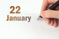 January 22nd. Day 22 of month, Calendar date. The hand holds a black pen and writes the calendar date. Winter month, day of the