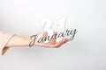 January 31st . Day 31 of month, Calendar date. Calendar Date floating over female hand on grey background. Winter month, day of