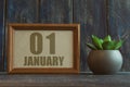 january 1st. Day 1 of month,  date in frame next to succulent on wooden background winter month, day of the year concept Royalty Free Stock Photo