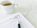 January 1st and a pen, first page of diary, and a cup of tea on a white marble texture background, close up. Royalty Free Stock Photo