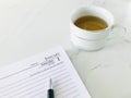 January 1st and a pen, first page of diary, and a cup of tea on a white marble texture background. Royalty Free Stock Photo