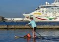 January 2023, Tampa, FL - Norwegian Dawn is headed through the channel while a paddle boarder keeps up with the cruise