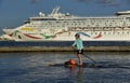 January 2023, Tampa, FL - Norwegian Dawn is headed through the channel while a paddle boarder keeps up with the cruise