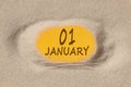 January 1. 1th day of the month, calendar date. Hole in sand. Yellow background is visible through hole