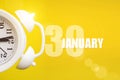 January 30th. Day 30 of month, Calendar date. White alarm clock on yellow background with calendar day. Winter month, day of the