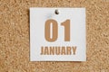january 01. 01th day of the month, calendar date.White calendar sheet attached to brown cork board.Winter month, day of