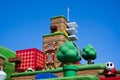 Japan - April 03, 2023: Shy guy walking on a game pixel block with green warp pipe, cloud floating and check point flag in Super