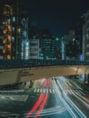 Vibrant Tokyo streets come alive in this retro long-exposure shot, neon lights trail with vintage colors and motion.