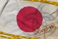 Japan flag and Covid-19 biohazard symbol with quarantine orange tape and stamp. Coronavirus or 2019-nCov virus concept