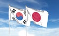 Japan flag and South Korea flag on cloudy sky. waving in the sky Royalty Free Stock Photo