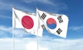 Japan flag and South Korea flag on cloudy sky. waving in the sky Royalty Free Stock Photo